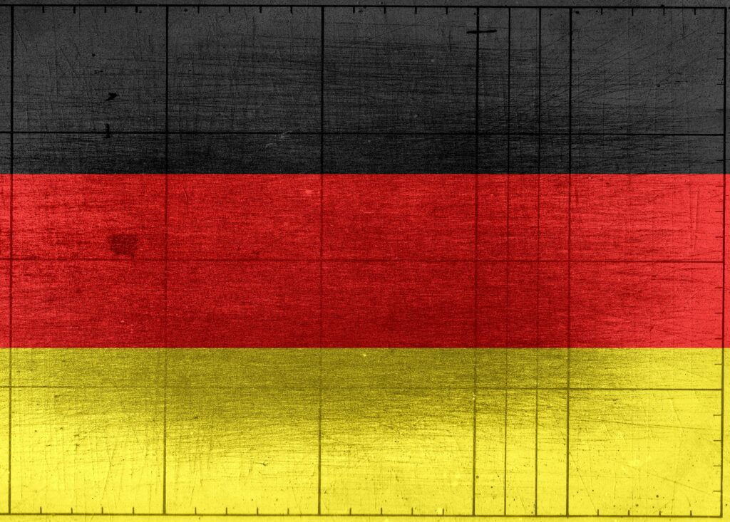 Grungy background designed as flag of Germany on shabby wooden board with measure scale